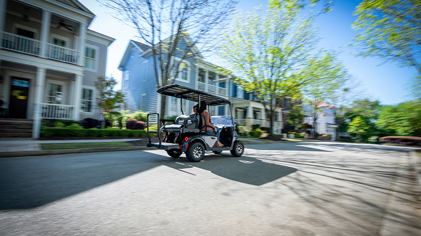 An E-Z-GO golf cart driving down an empty street.