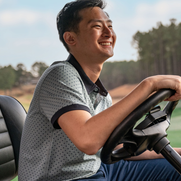 A person behind the wheel of an E-Z-GO golf cart.