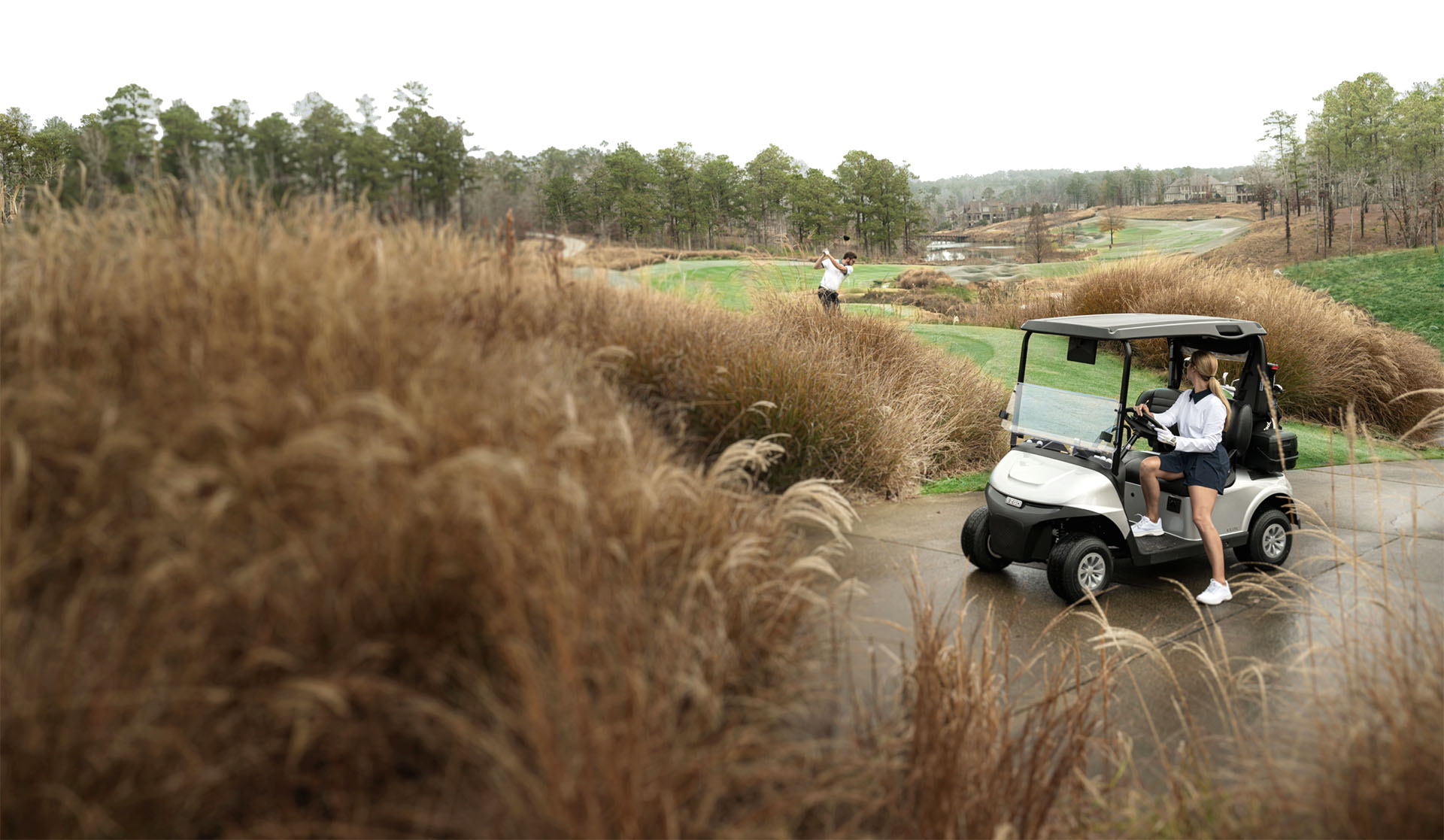 A woman getting out of an E-Z-GO golf cart.