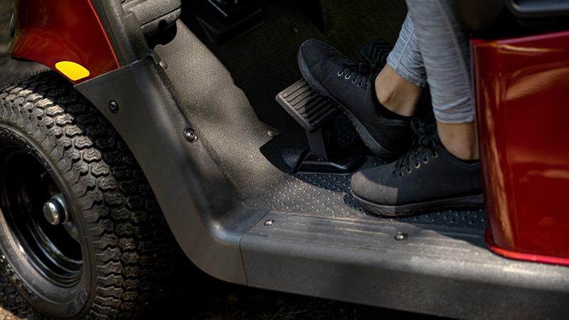 A foot pressing the pedals of their E-Z-GO golf cart.