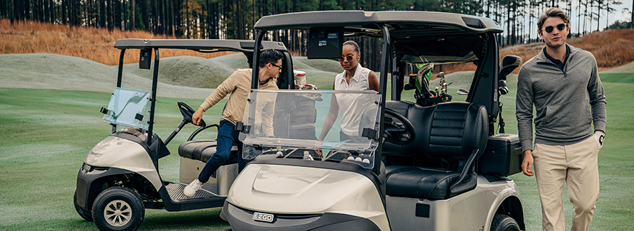 A group of golfer depart their E-Z-GO on the golf course.