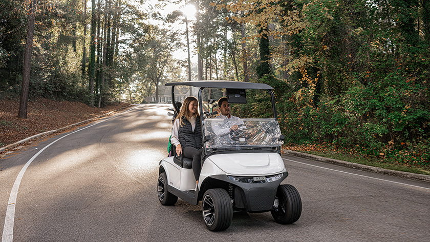 Passengers enjoy a ride in an E-Z-GO golf cart.