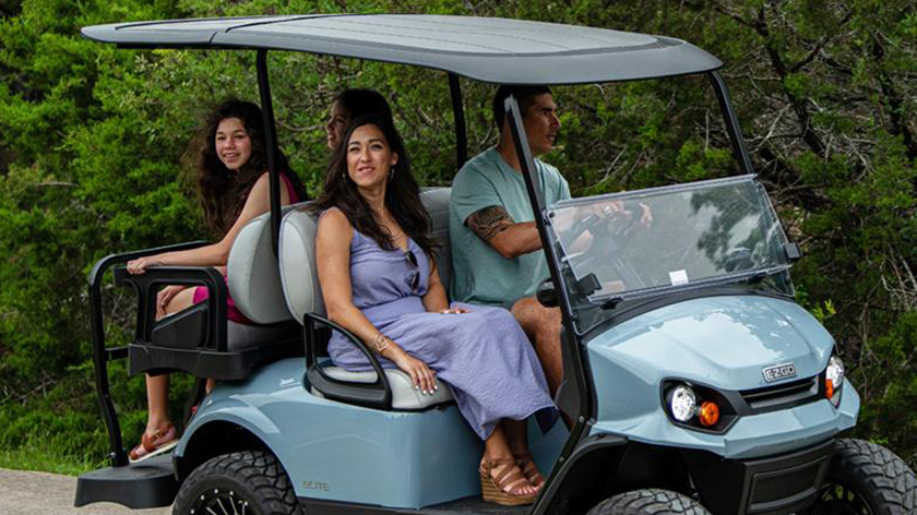 Passengers enjoy a ride in an E-Z-GO golf cart.