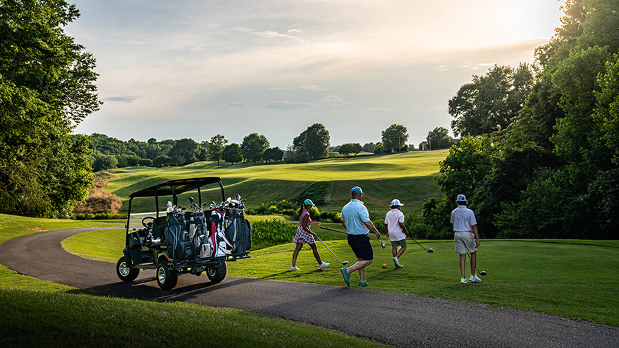 Four golfers walking away from their E-Z-GO golf cart, featuring the 4-golf bag mount option.