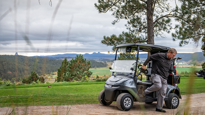A golfer departing their E-Z-GO golf cart.