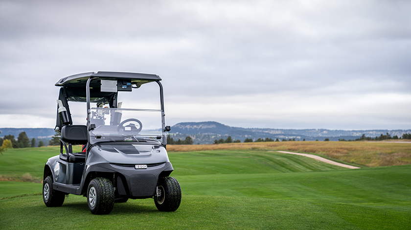 An E-Z-GO golf cart sitting on a golf course.