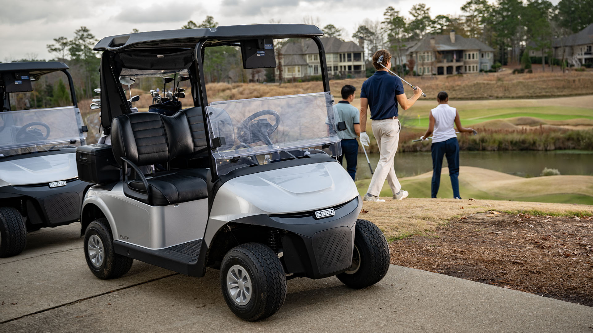 Golfers walking away from their E-Z-GO golf carts.