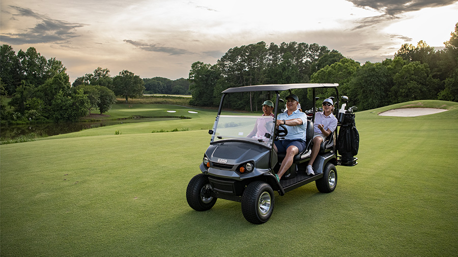 An E-Z-GO Liberty model driving on a golf course turf.
