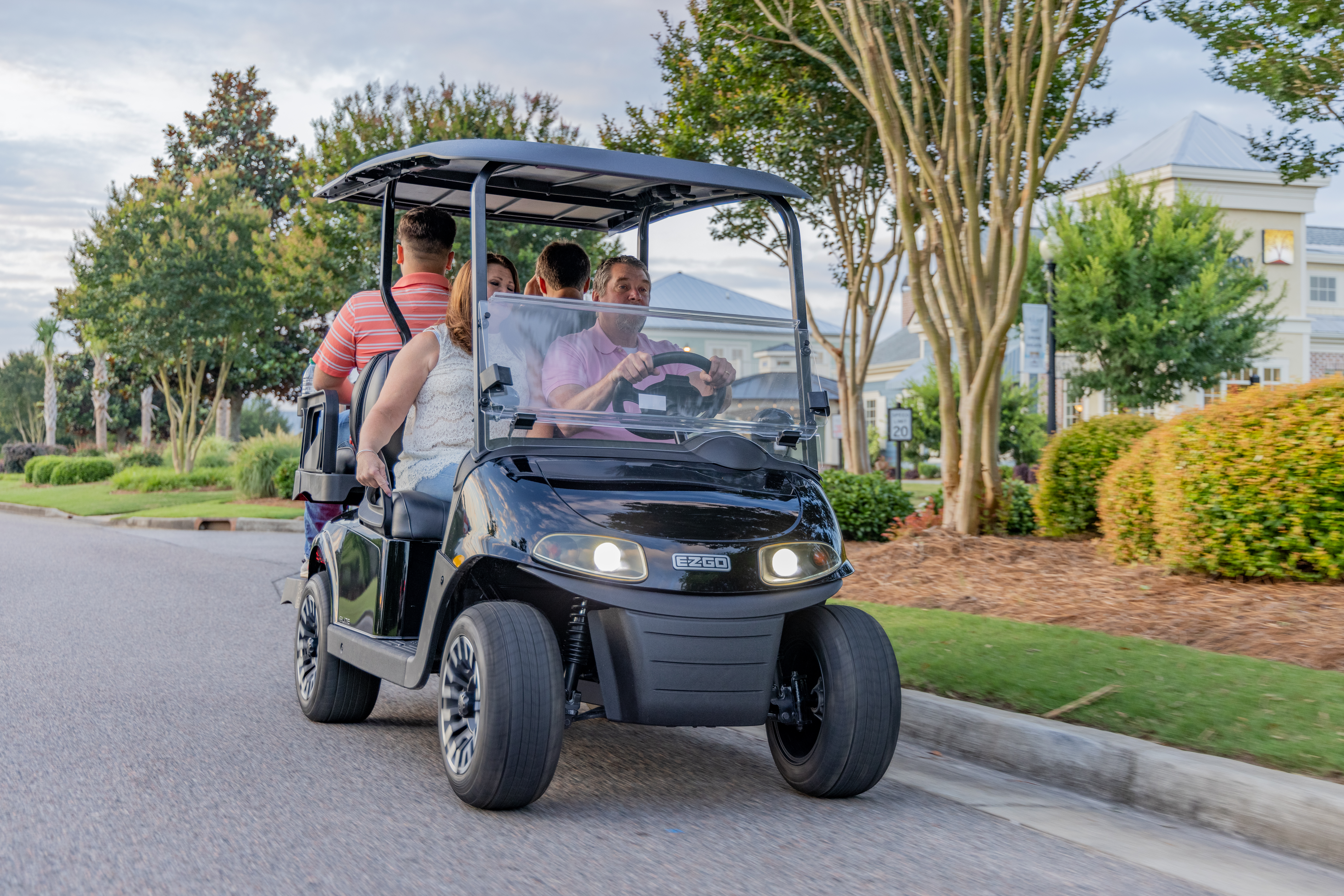Family riding E-Z-GO golf cart
