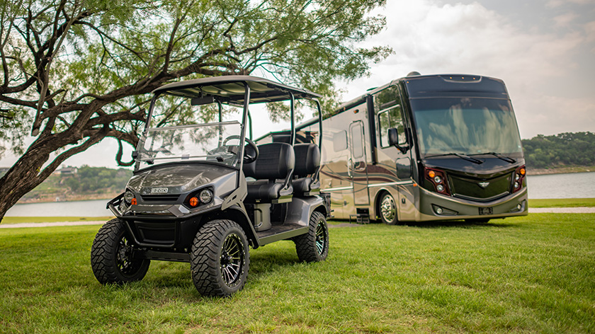 E-Z-GO Liberty golf cart in front of a parked RV.
