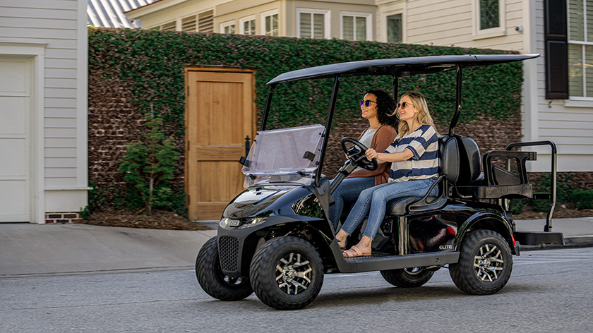 Two riders in an E-Z-GO golf cart.