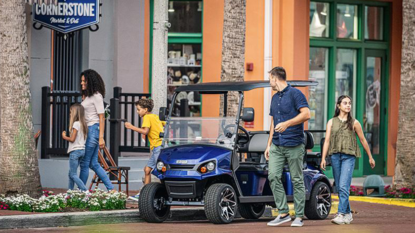 A family gathers to get inside their Express S6 golf cart.