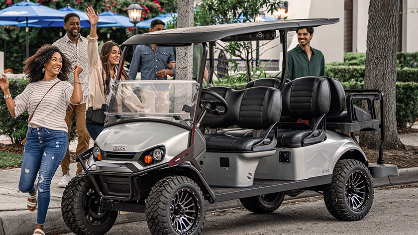Friends gather around to ride an E-Z-GO Express L6 golf cart.