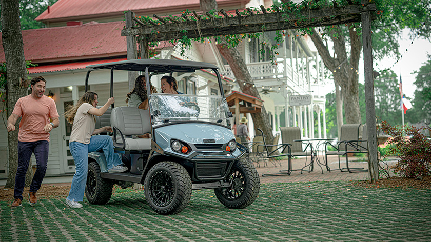 Liberty 4 full of friends getting on their E-Z-GO after shopping
