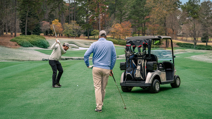 E-Z-GO RXV 2 two-bag attachment on the back of the vehicle with customers playing golf