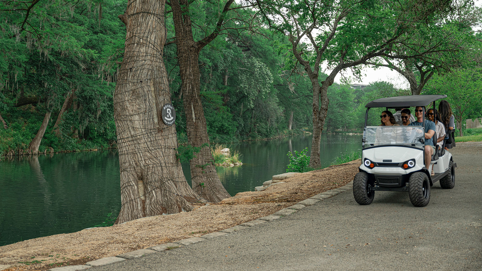 Bright white Express 6 driving on a gravel road by the river