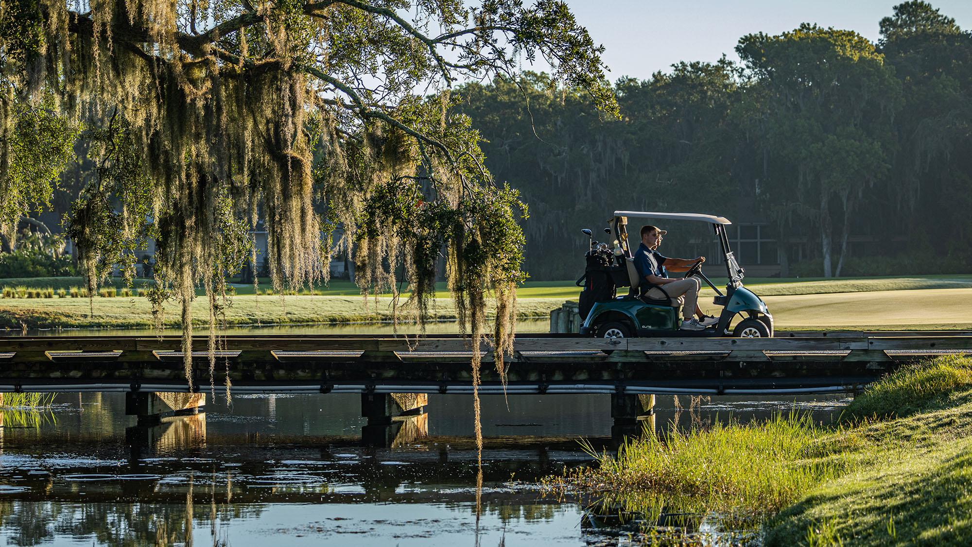 E-Z-GO RXV ELiTE Riding across a bridge on a golf course 