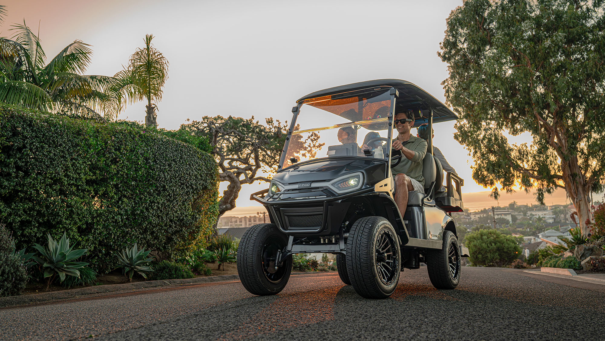 Express 4 driving in a neighborhood with a sunset, shrubs, and trees in the background