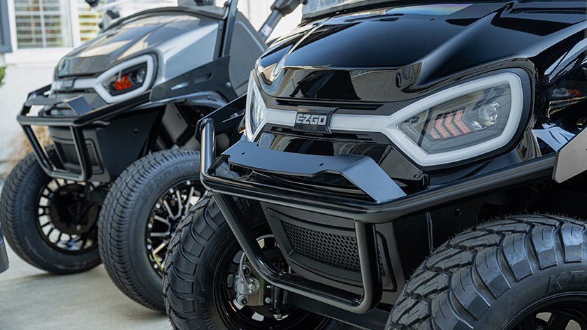 Two E-Z-GO carts with LED headlights showing off brush guard and E-Z-GO emblem