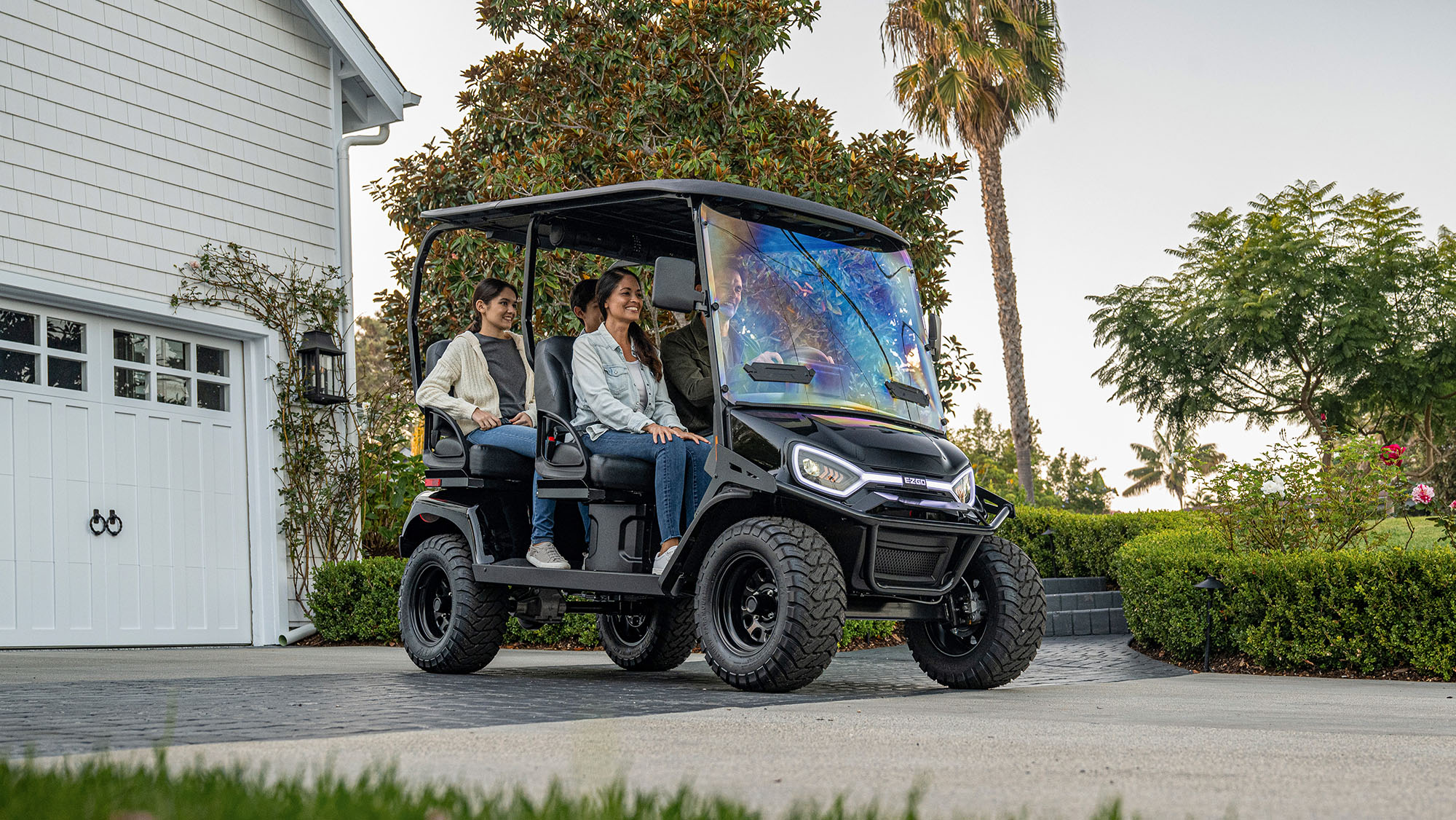 Liberty LSV in front of a house parked in the driveway with family of 4 in the cart.