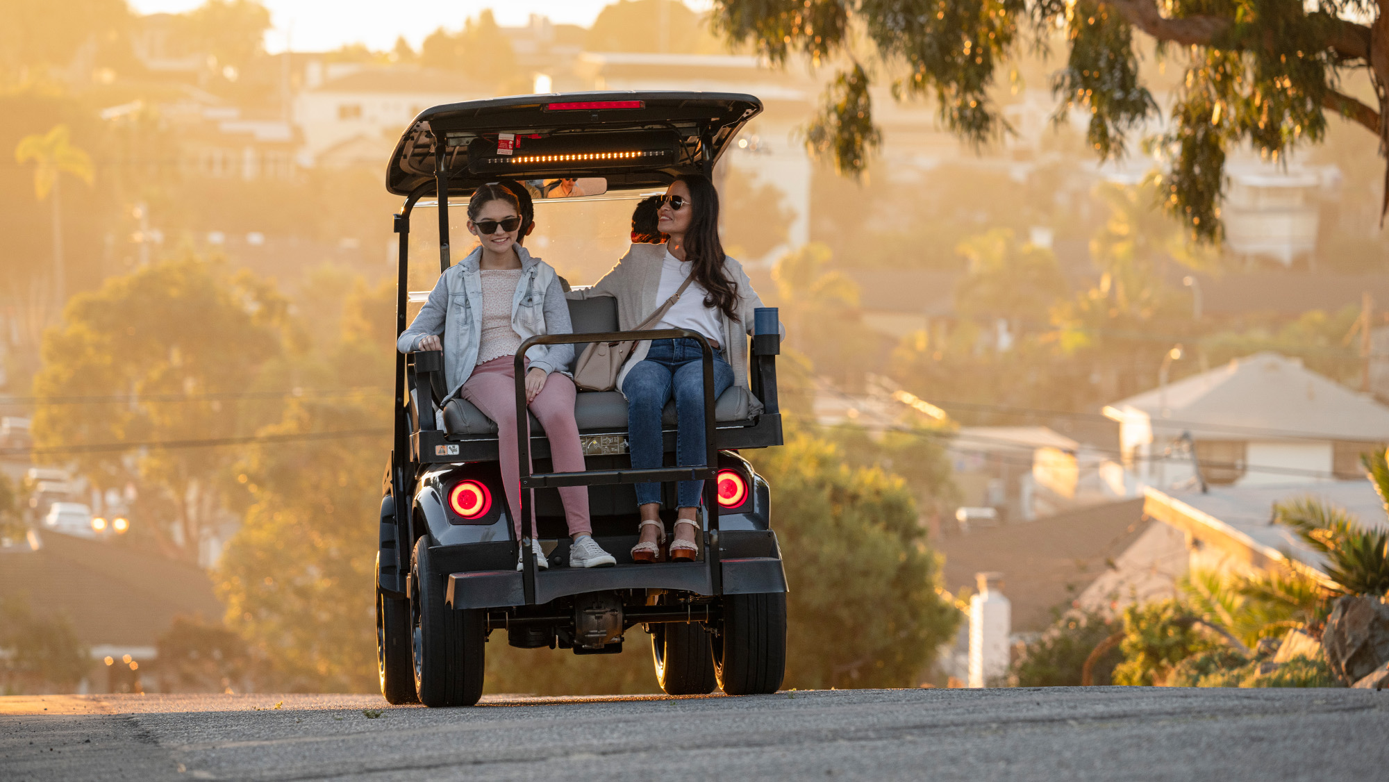 Express 4 driving in a neighborhood with sound bar on and mom and daughter in the back