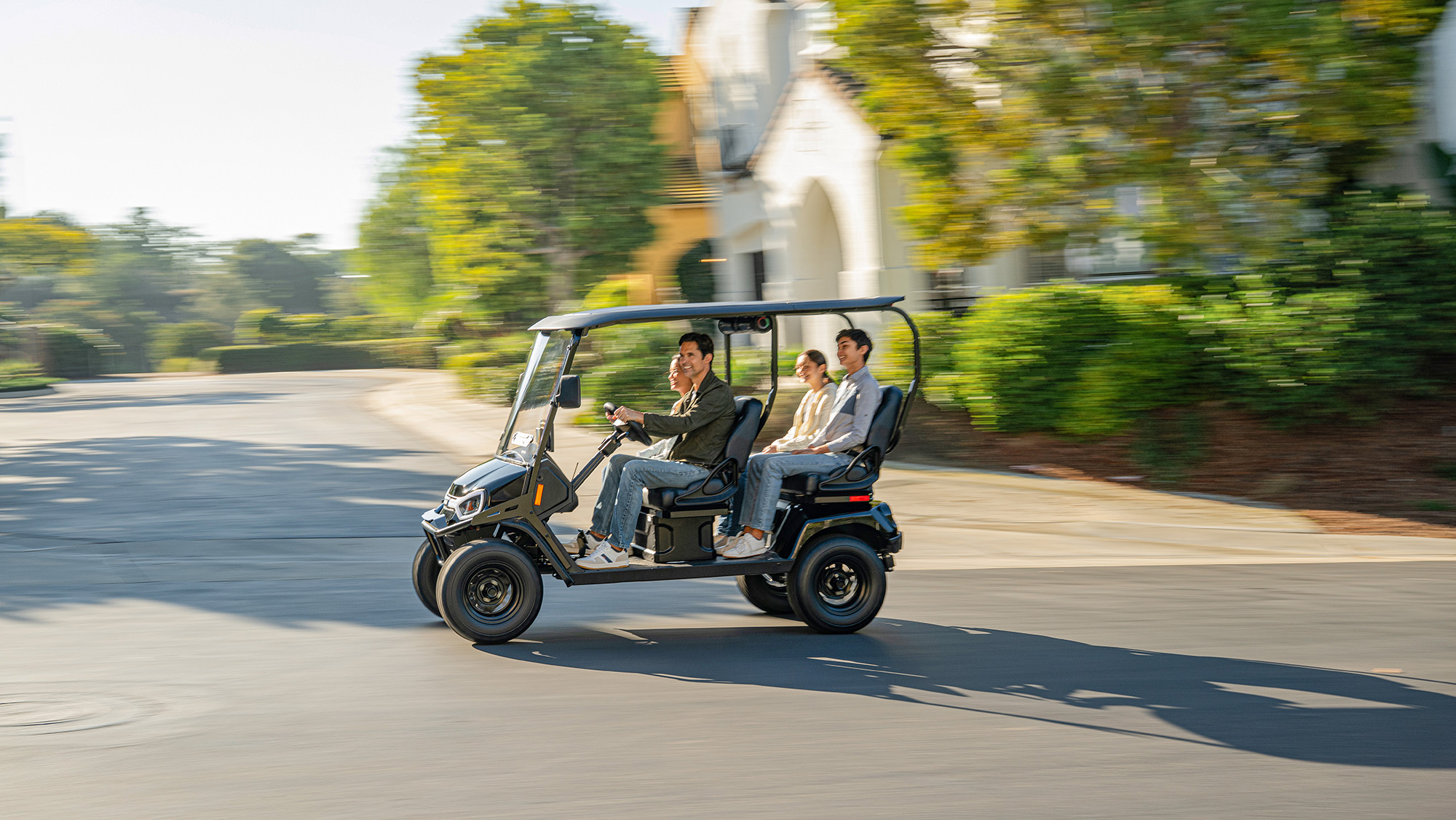 Liberty LSV driving in a neighborhood with a family of 4 riding in the golf cart
