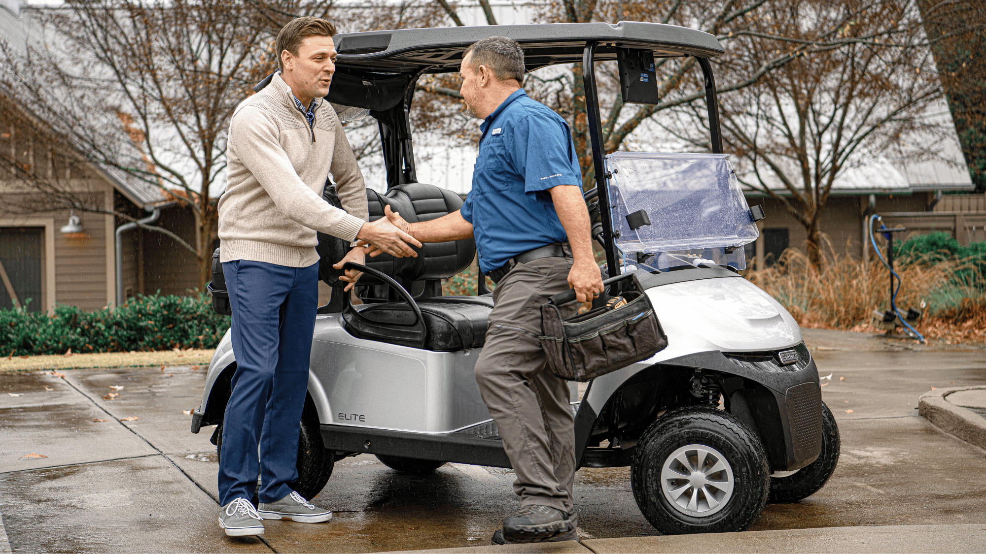 E-Z-GO Technician shaking hands with a happy E-Z-GO customer after a maintenance service. 
