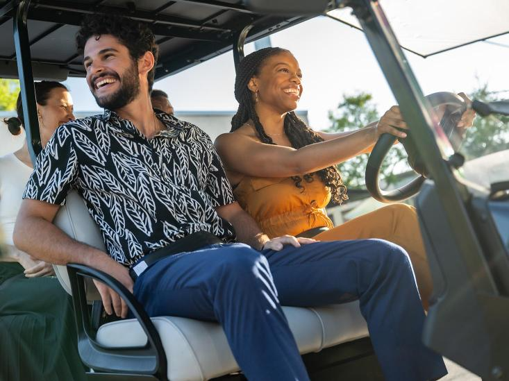 Four passengers enjoy a ride in their E-Z-GO golf cart.