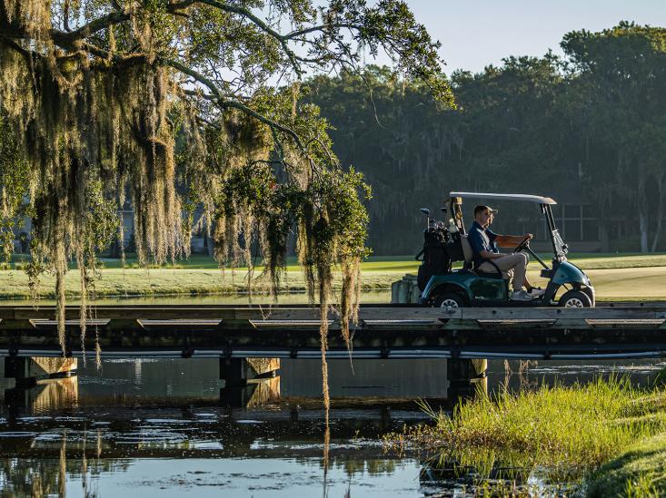 E-Z-GO RXV ELiTE Riding across a bridge on a golf course 